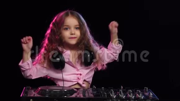 女孩在转盘上玩耍和跳舞黑色背景慢动作视频的预览图