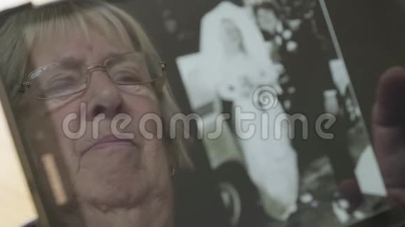 一位年长妇女在平板电脑上看旧照片的反映视频的预览图