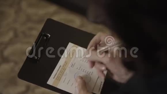 女人的手拿着一个黑色的文件夹上面写着一份文件视频的预览图