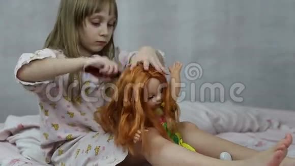 坐在床上玩娃娃的女孩视频的预览图
