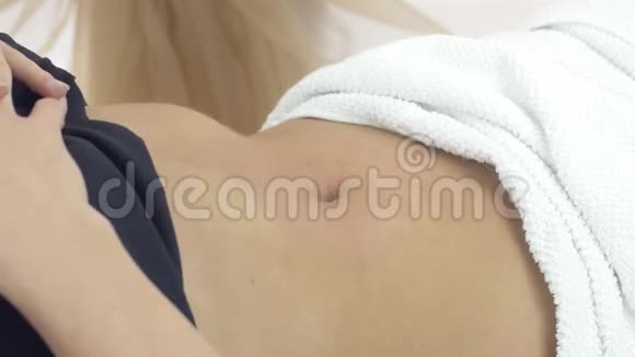 美容师做女孩胃按摩在美容院用毛巾覆盖视频的预览图