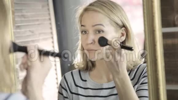 美丽的女人每天化妆拿着化妆刷在镜子前视频的预览图