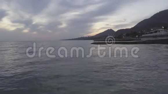 令人惊叹的黑海风光海岸线夕阳下的青山与多云的天空视频的预览图