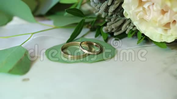 大理石背景的两个金色结婚戒指视频的预览图