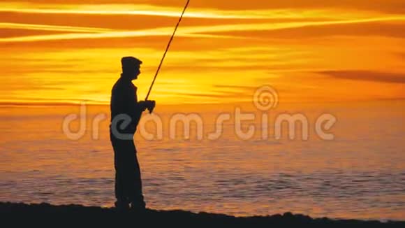 渔人剪影海上日落时的钓鱼竿视频的预览图