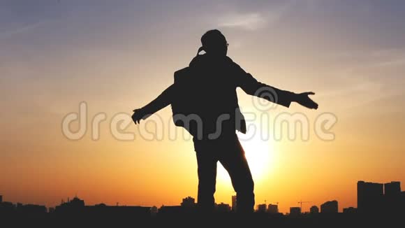 一个背着背包的男人在明亮的天空中的剪影视频的预览图