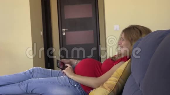 幸福的孕妇给自己和圆肚子拍照视频的预览图