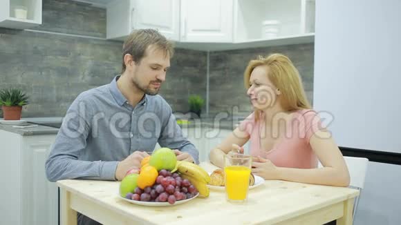 厨房里的年轻夫妇喝茶吃水果视频的预览图