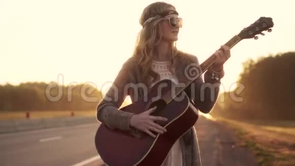 嬉皮女孩弹吉他黎明时戴墨镜的少女画像视频的预览图
