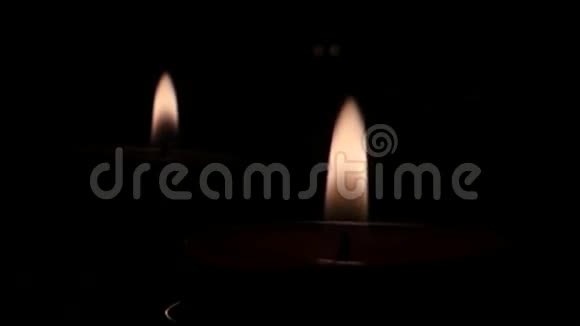 黑暗中两支蜡烛的火教堂里的风视频的预览图