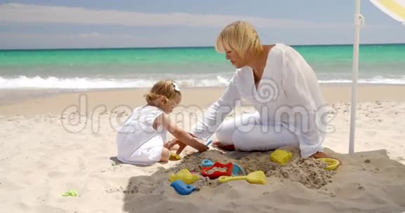 可爱的女孩和祖母在海滩上玩耍视频的预览图