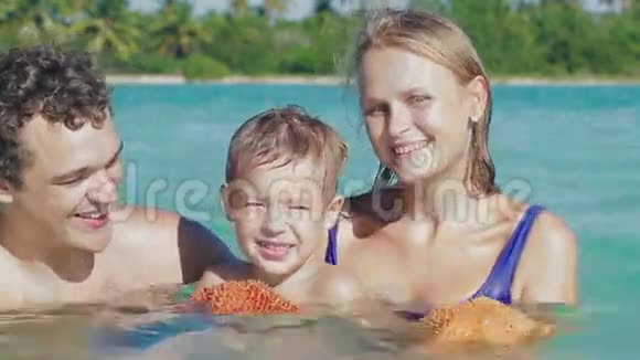 父母和他们的小儿子在海水中视频的预览图