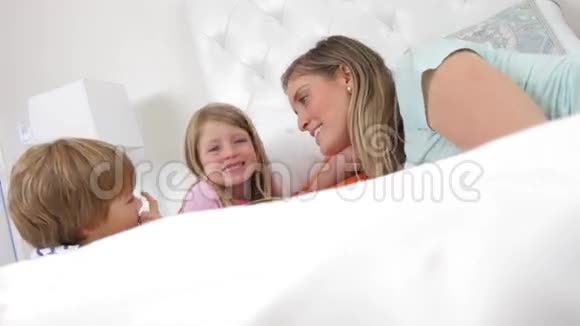 母亲和孩子一起躺在床上看书视频的预览图