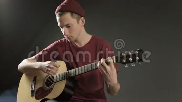 聪明的年轻音乐家在黑暗中弹吉他视频的预览图