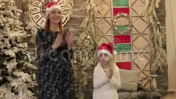 戴圣诞帽的母亲和女儿庆祝圣诞节和新年视频的预览图