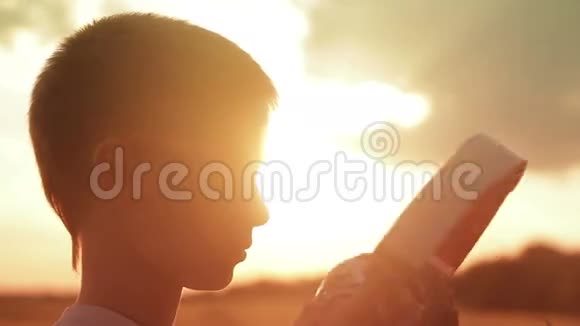 日落时分男孩在田野里戴着耳机视频的预览图