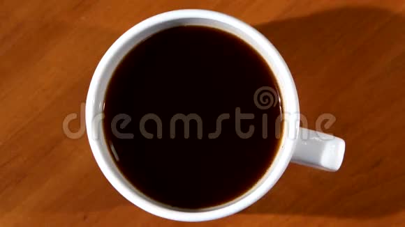 人用手在一杯黑咖啡里搅拌糖视频的预览图
