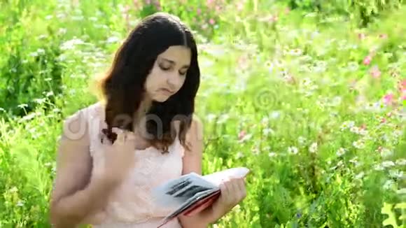 黑发女孩在读一本关于自然的书视频的预览图