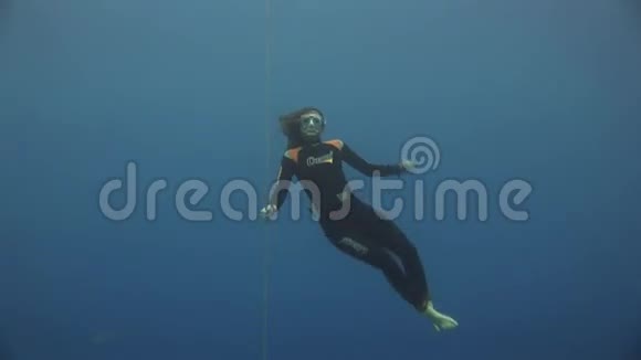 水下模型自由潜水员用红色浮标在红海干净的蓝色水中游泳视频的预览图