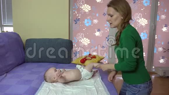 妈妈和婴儿一起在沙发上做运动宝宝翻肚子视频的预览图