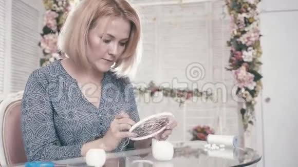 年轻女孩坐在桌子旁做装饰元素视频的预览图