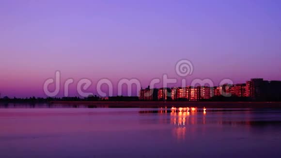 日落时带湖的城市景观黄昏时分的花旗景观与金色的倒影视频的预览图