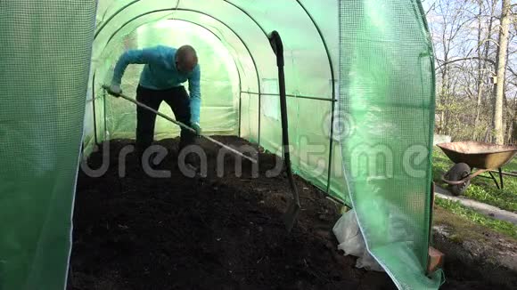 园丁在新的温室里用土壤辛勤劳动视频的预览图