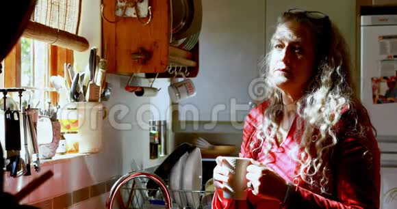 厨房里有咖啡的成熟女人视频的预览图
