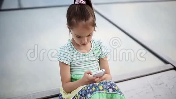 漂亮的孩子小女孩喜欢智能手机视频的预览图