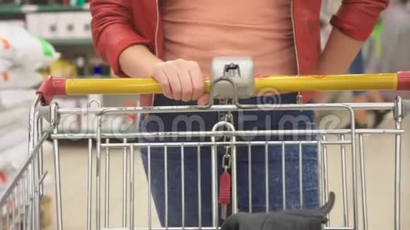 超市里的一个女人正从柜台边经过篮子4k视频的预览图