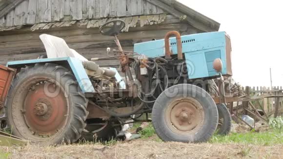 一辆生锈的旧拖拉机站在田野附近农业机器正在等待田间的加工视频的预览图