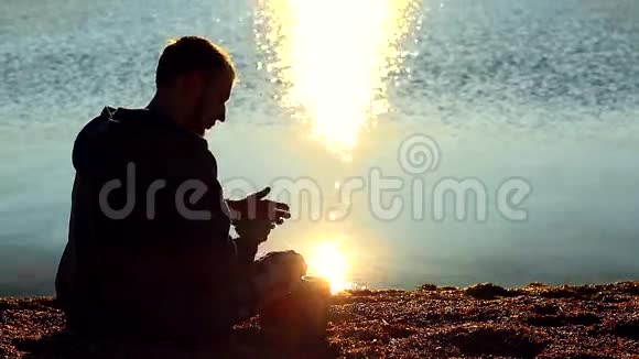 海滩上的男人在用手机说话视频的预览图