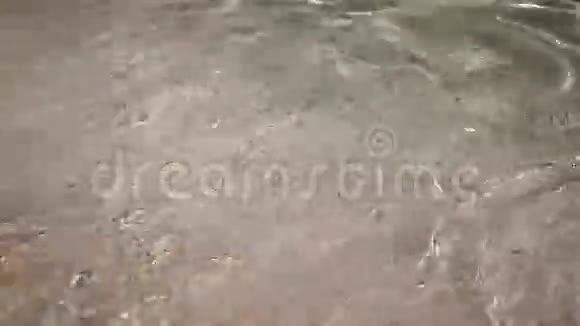 海水冲刷着沙质的海岸并再次流出视频的预览图