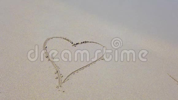 海浪冲刷掉的沙滩上的心形图案视频的预览图