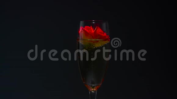 一杯香槟和玫瑰花蕾黑色背景视频的预览图