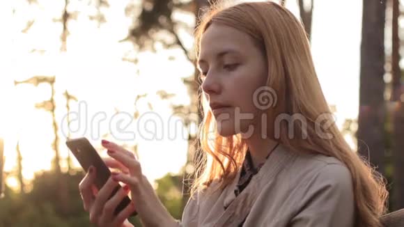 红发女孩使用手机的侧视图视频的预览图