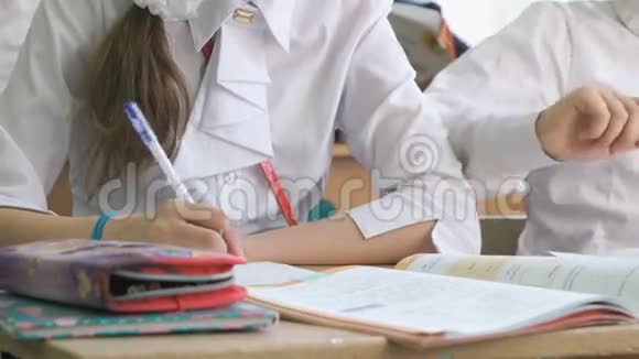 女孩用圆珠笔在笔记本上写课文视频的预览图