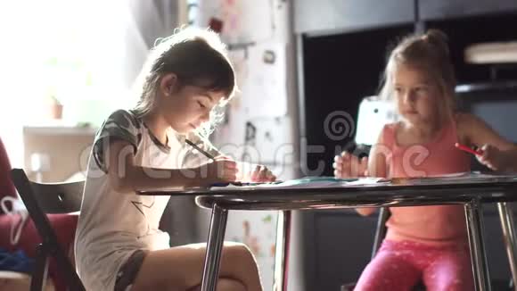 孩子们在家坐在桌子旁用铅笔画画2妹妹在厨房里画画视频的预览图