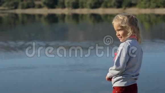一个漂亮的小女孩在池塘边玩耍视频的预览图