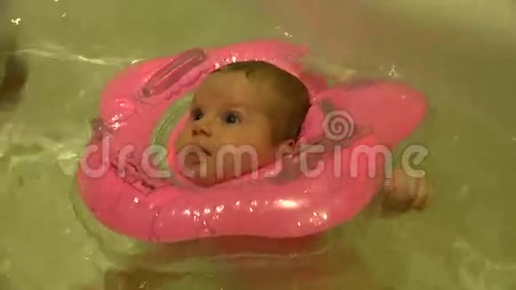 婴儿游泳与颈部游泳环在游泳池4k超高清视频的预览图