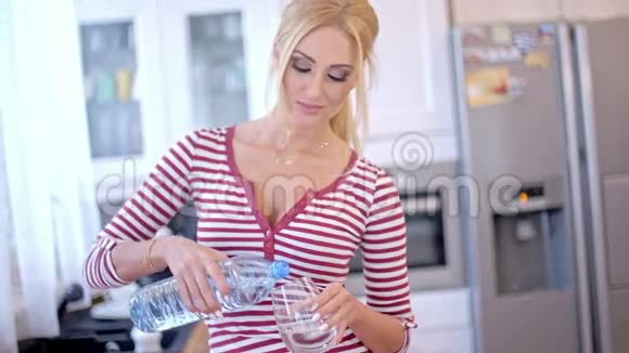 年轻漂亮的女人倒瓶装水视频的预览图