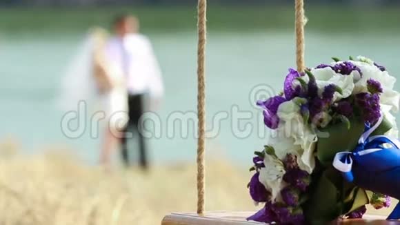 婚礼花束在跷跷板上背景模糊的已婚夫妇视频的预览图