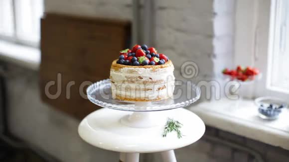 女厨师用新鲜草莓蓝莓装饰饼干蛋糕视频的预览图