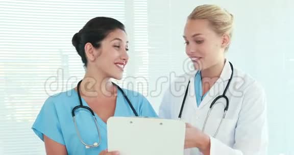 两个医生一起说话看着剪贴板视频的预览图