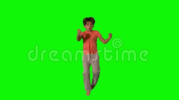 男孩在绿色的屏幕上跳跃和欢呼视频的预览图