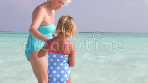 祖母和孙女在美丽的海滩上收集岩石视频的预览图