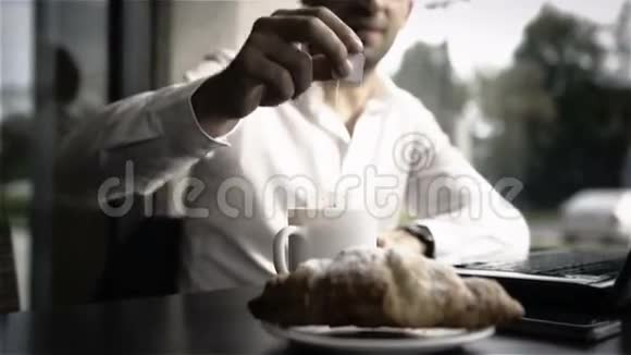 商务早餐包括牛角面包一杯茶和笔记本电脑视频的预览图
