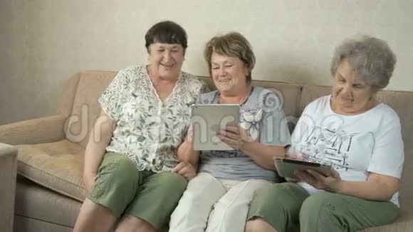 老年妇女在平板电脑屏幕上观看照片视频的预览图