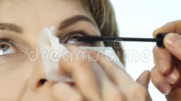 专业化妆师在眼睑上涂眼线的特写画师用眼线来弥补女性视频的预览图