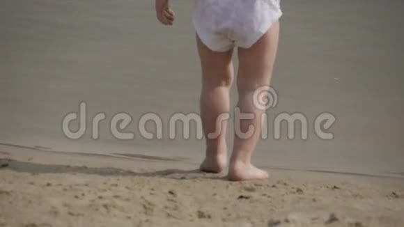 穿着游泳短裤在沙滩上玩耍的小男孩视频的预览图
